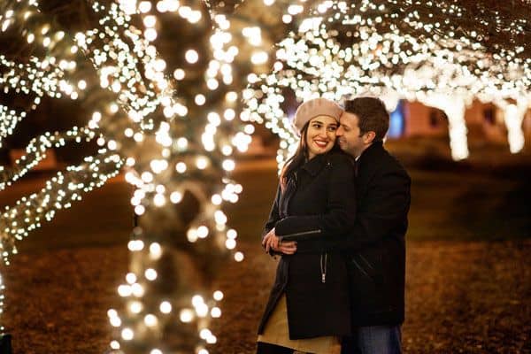 Couples taking holiday selfies under the lights 